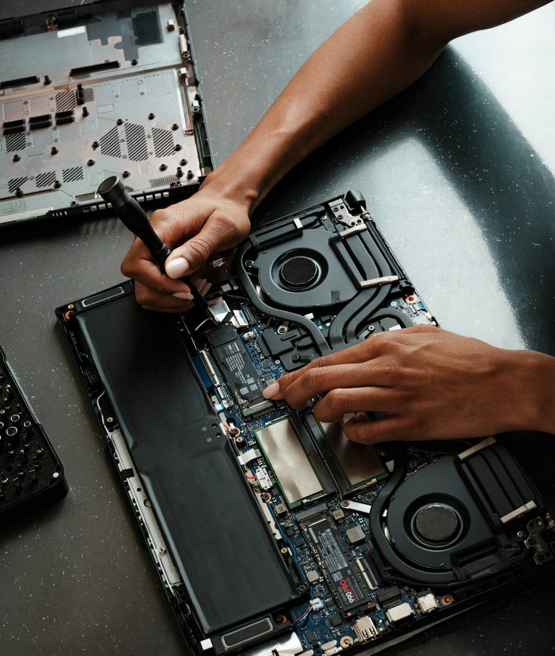 Technician repairing a laptop motherboard